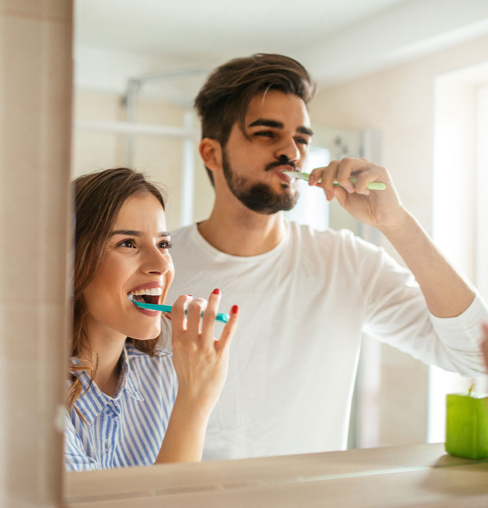 couple brushing their teeth in the morning in their bathroom